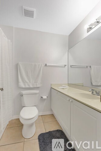 A white toilet sits in a bathroom next to a sink.