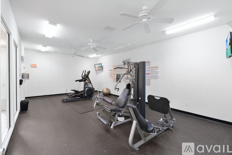 A gym room with a row of exercise equipment.