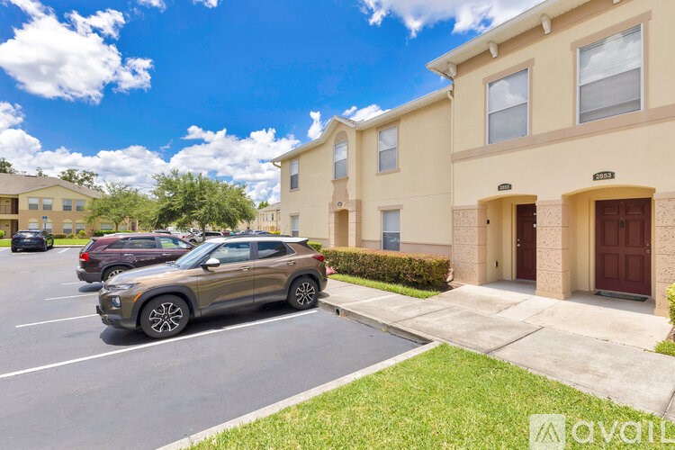A car is parked in a parking lot in front of a building.