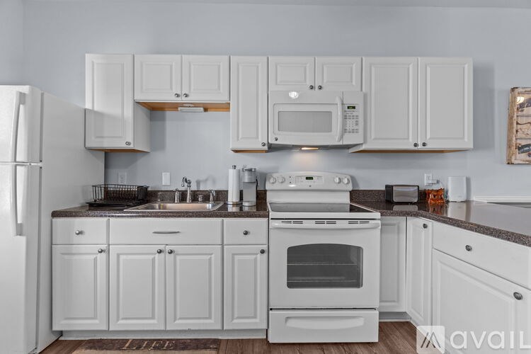 A kitchen with white cabinets and appliances.