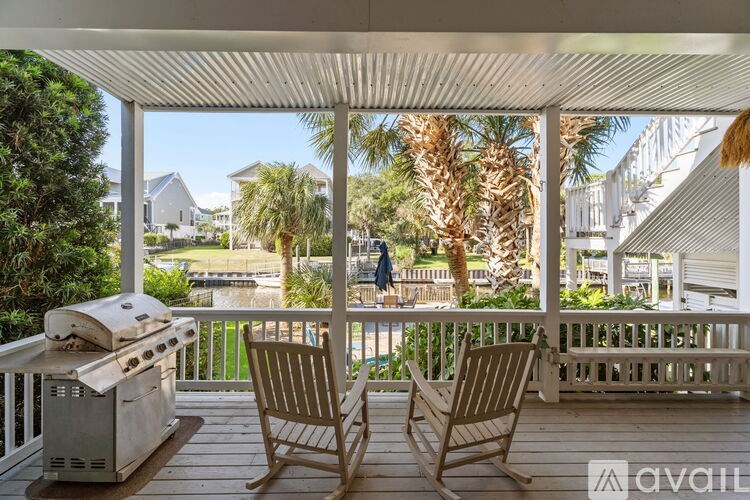A patio with two chairs and a grill.