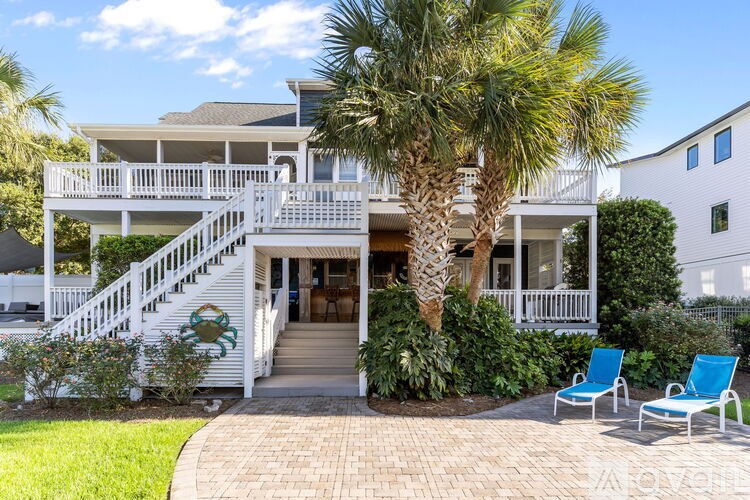 A porch with two chairs and a grill.