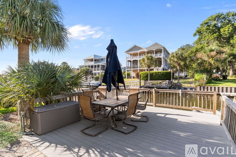 A patio with a table and chairs overlooking a house.