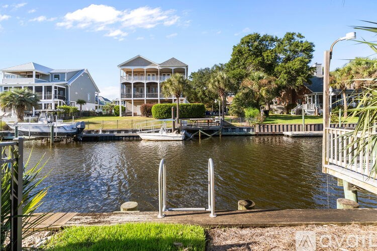 A bedroom with a bed, lamp, and pictures on the wall.