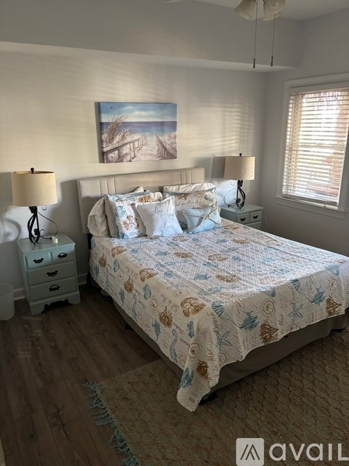 A bedroom with a large bed and a painting on the wall.