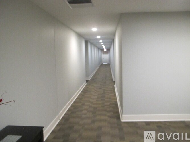 A long hallway with a carpeted floor and white walls.