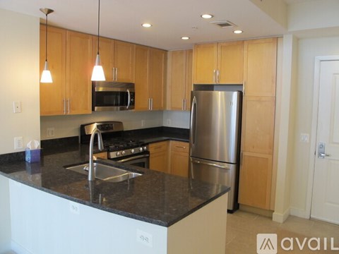 A kitchen with wooden cabinets and a black countertop.