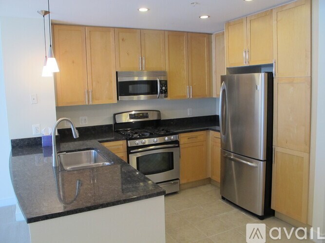 A kitchen with wooden cabinets and a stainless steel refrigerator.