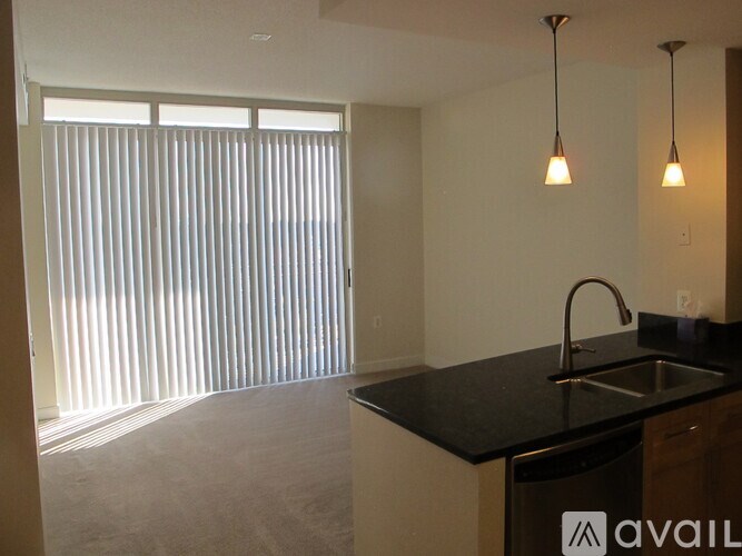 A kitchen with a sink and a window with blinds.