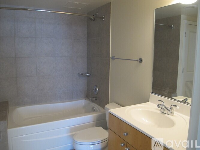 A bathroom with a white tub, toilet, and sink.