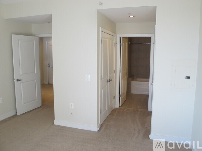 A room with white doors and beige carpet.