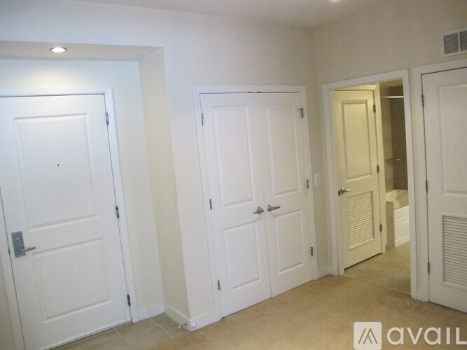 Three white doors in a room with a carpeted floor.