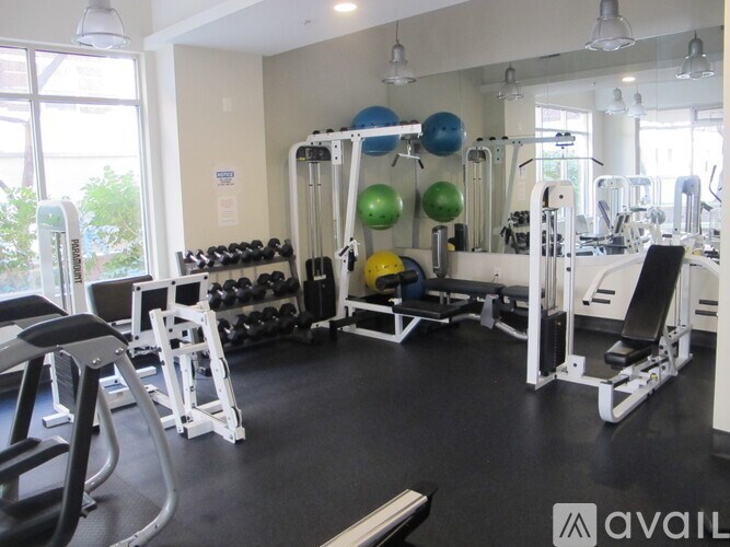 A gym with a variety of equipment including weights and exercise balls.