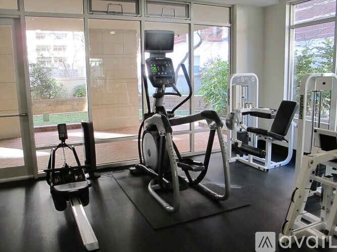 A gym with a stationary bike, a leg press machine, and a squat rack.