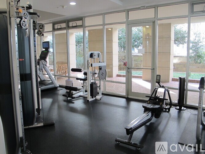 A gym with a variety of equipment including treadmills, weights, and exercise machines.