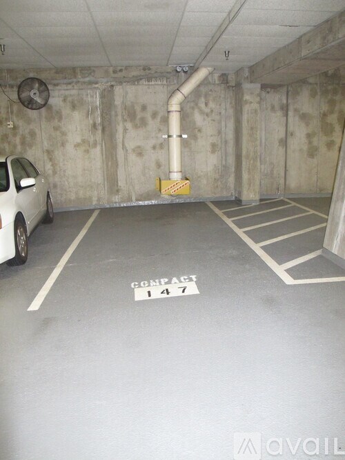 A white car is parked in a parking space labeled "CONFIDENTIAL 147".