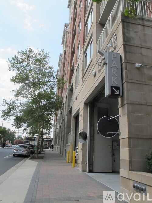 A street view with a sign that says "PARK" and a car parked on the side of the road.