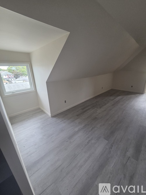 A room with wooden flooring and a window.