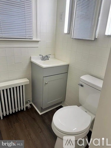 A white toilet sits next to a white sink in a small bathroom.
