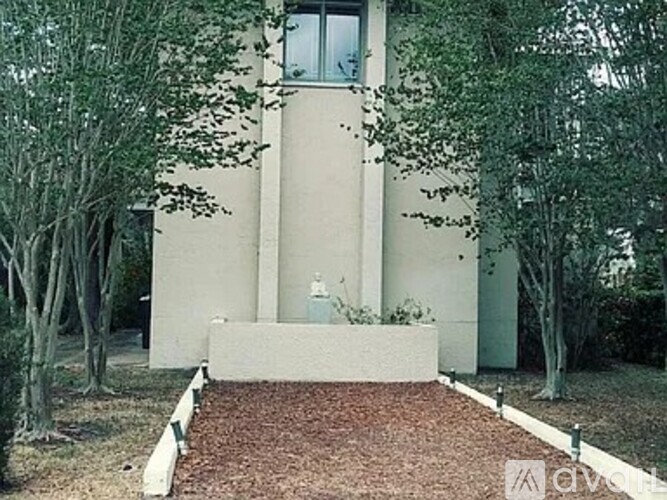 A small house with a red brick pathway leading to the front door.