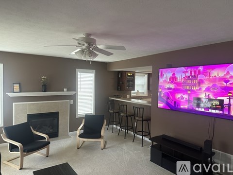 A living room with a television displaying a pink cityscape.