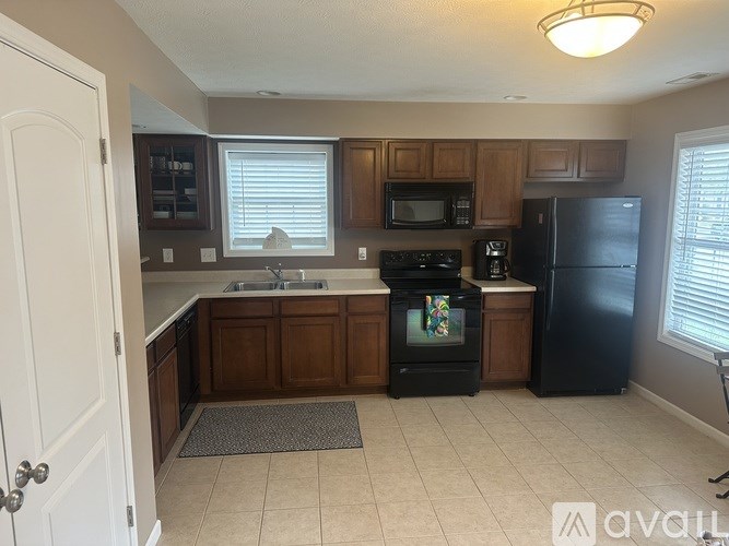 A kitchen with a black fridge and a black oven.