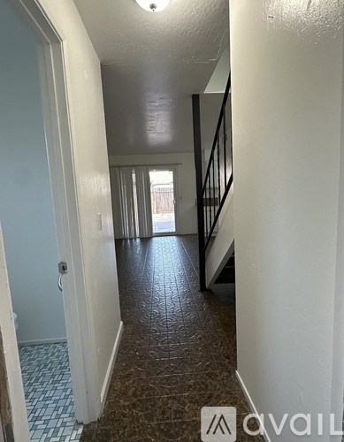 A hallway with a tiled floor and a staircase.