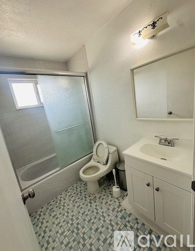A bathroom with a toilet, sink, and shower.