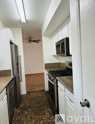 A kitchen with a black stove top oven and a black microwave above it.