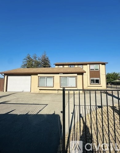 A house with a brown roof and a black gate in front.