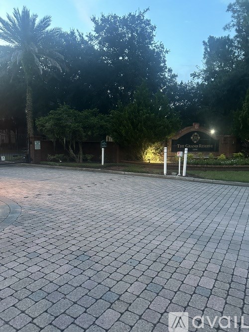 A brick walkway leads to a building with a sign that reads "The Grand Residence.".