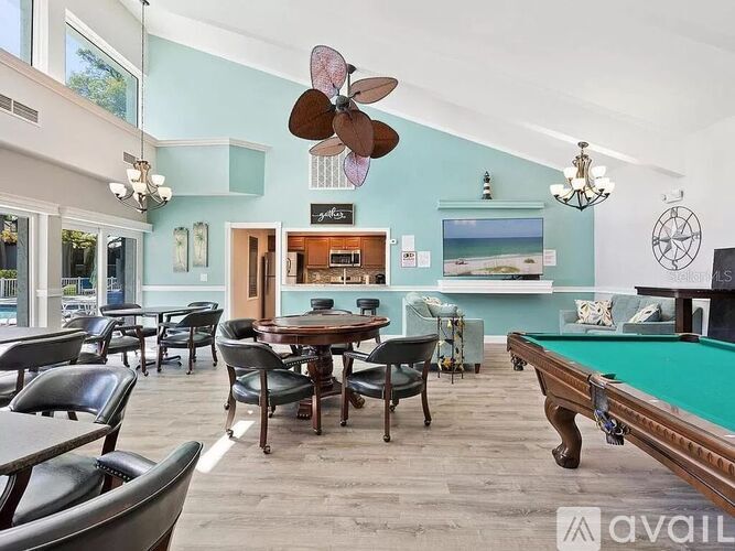 A room with a pool table and a bar area.