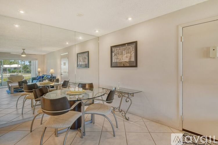 A modern dining room with a glass table and chairs.
