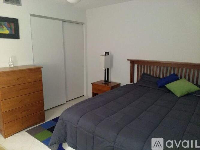 A bedroom with a bed, nightstand, and a dresser.