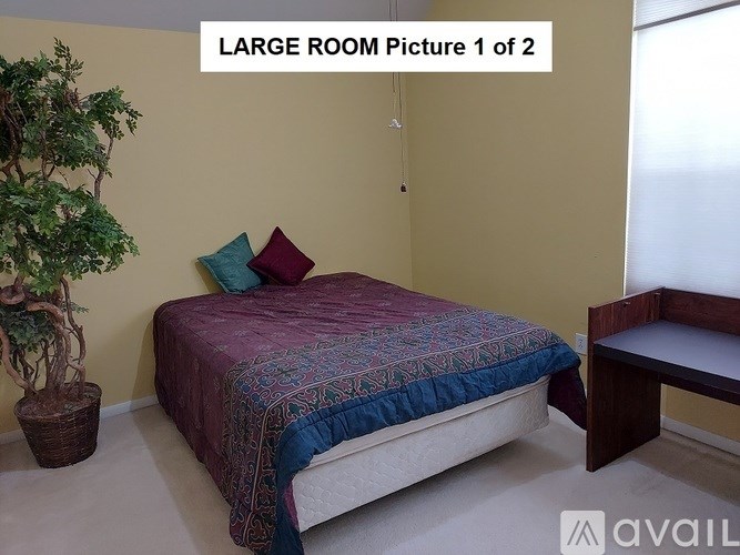 A bedroom with a bed, a bench, and a potted plant.