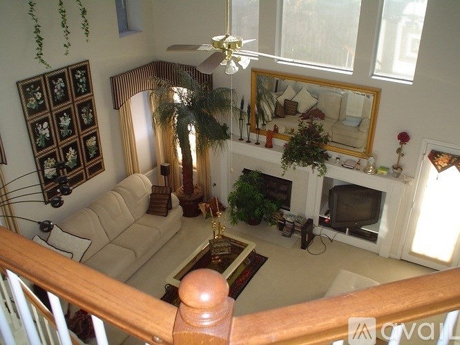 A living room with a couch, a television, and a fireplace.