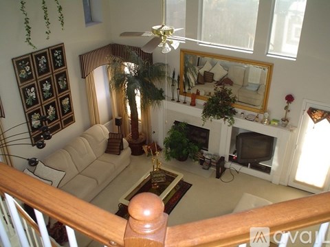 A living room with a couch, a television, and a fireplace.