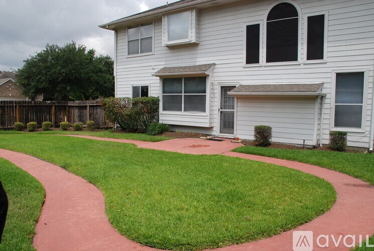 A white house with a red pathway in front of it.