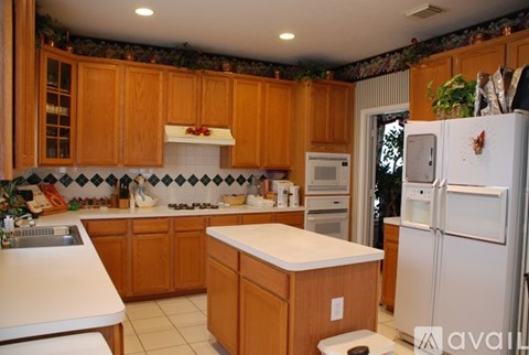 A kitchen with wooden cabinets and a white fridge.