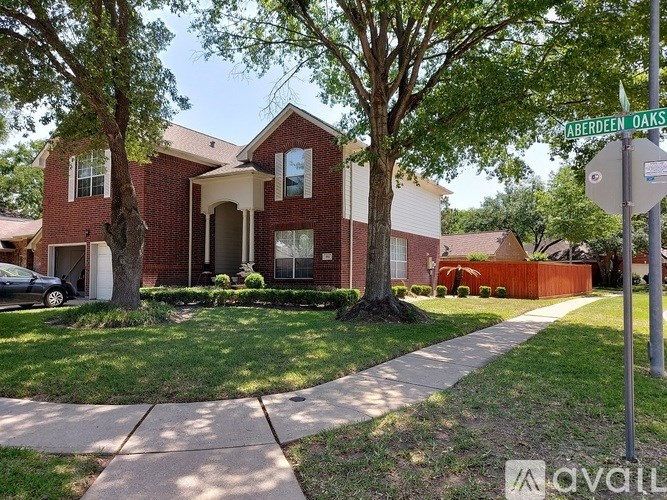 A house with a red brick facade is located at the corner of a street.