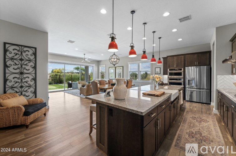 A modern kitchen with a large island and pendant lights.
