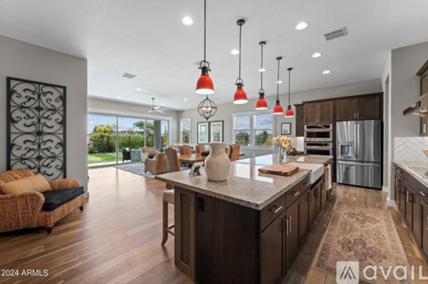 A modern kitchen with a large island and pendant lights.