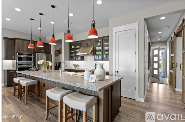 A kitchen with a bar area and a view of the hallway.