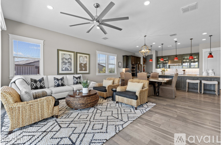 A living room with a white ceiling fan and a patterned rug.