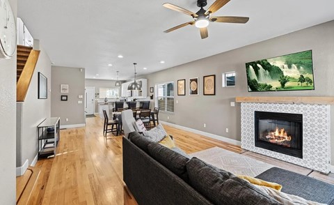 A living room with a fireplace and a painting of a waterfall on the wall.