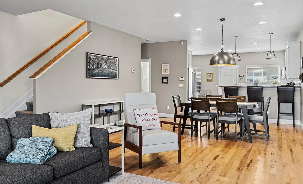 A living room with a grey couch and a sign that says "Tenants please leave".