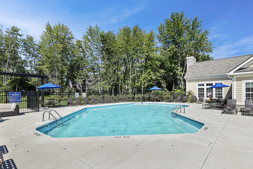 A swimming pool surrounded by trees and a house.