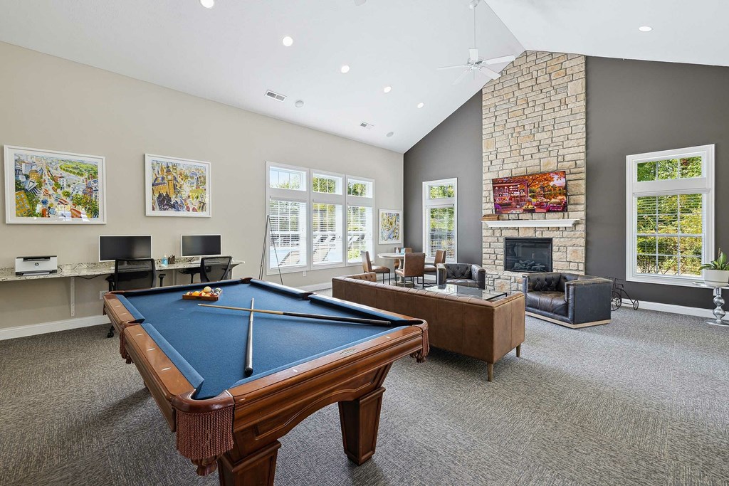 A patio with a couch and a table is surrounded by a black fence.