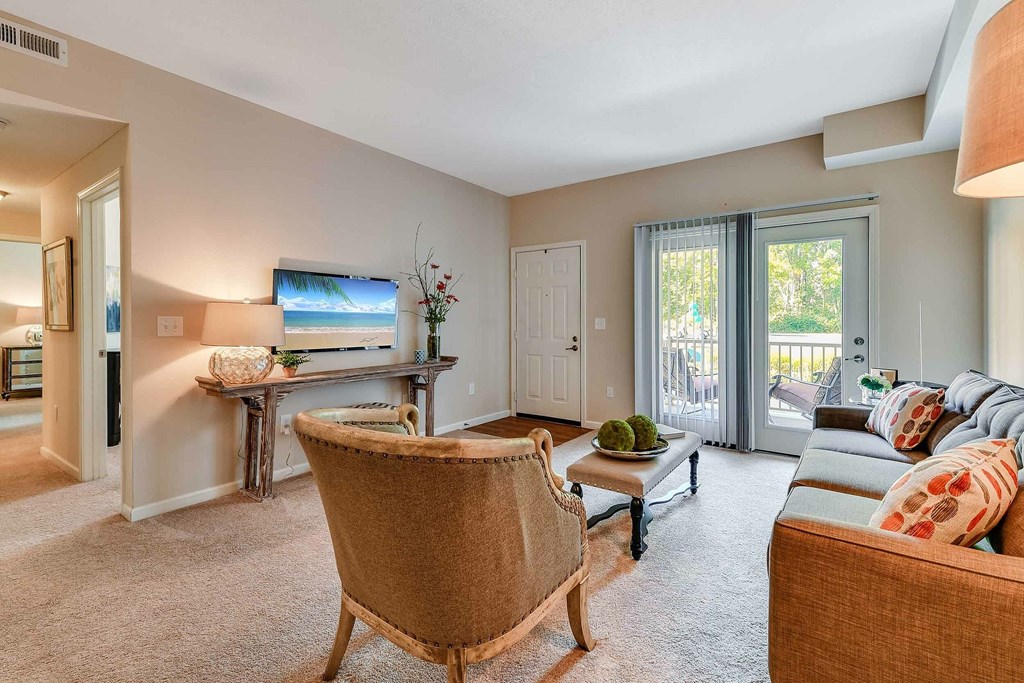 A living room with a chair, a couch, and a television.