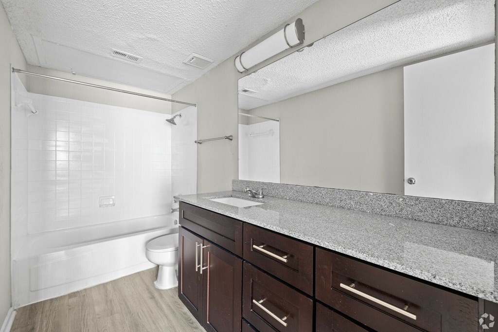 A bathroom with a toilet, sink, and shower.